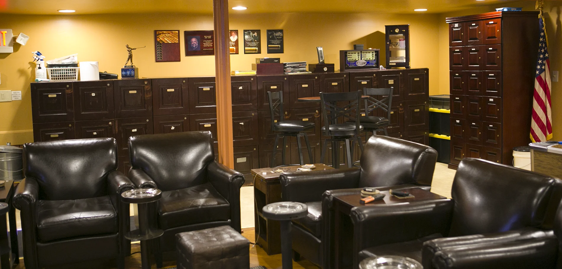 The main room at Exodus Cigar Lounge: leather club chairs and a wall of member humidor lockers