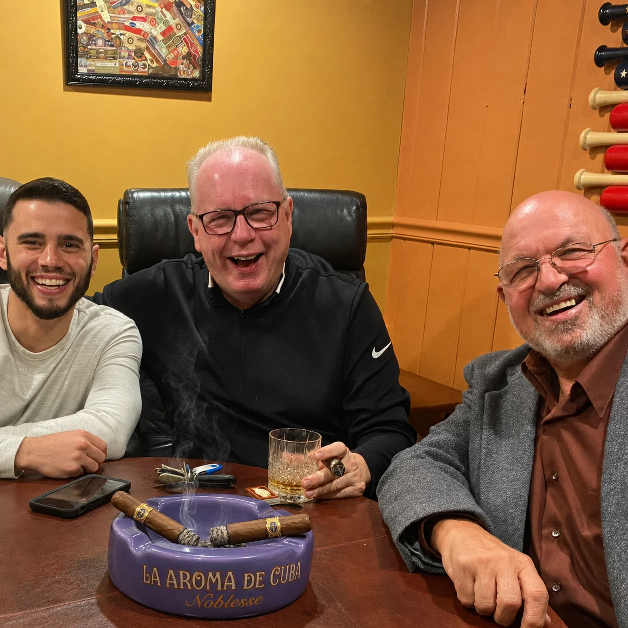 Three Exodus members sharing cigars and a drink around the lounge table
